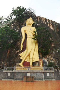 Phra Buddha Wichitman. Dışarıdan geçen yoldan görülebilen büyük bir Buda görüntüsü. Tham Ruesi Khao Ngu Tapınağı 'nda. Tayland 'ın Ratchaburi eyaletinde yer almaktadır..