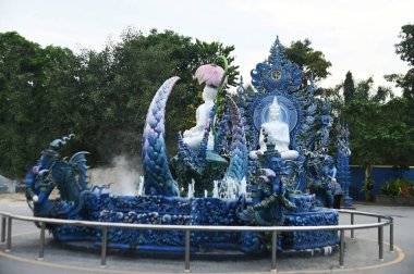 Dışarıdaki beyaz Buda 74. Buda 'dır ve Phra Upakut Wat Rong Suea Ten tapınağında süslenmiş inci beyazı bir heykeldir. Tayland 'ın Chiang Rai Eyaleti' nde..