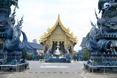 Phra Upakut nilüfer çiçeğinin gölgesinin altındaki bir çeşmenin ortasına yerleştirilmiş inci beyazı bir heykeldir. Wat Rong Suea 10 tapınağındaki kilisenin önünde. Tayland 'ın Chiang Rai şehrinde..