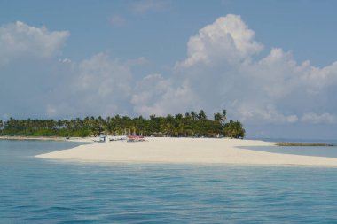 Sıcak ve açık bir günde palmiye ağaçlarıyla güzel beyaz kumsallar ve yerel Filipinli tekneler ya da Avara Demiri tekneleri.