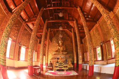 Büyük bir Buda heykeli altın renginde duruyor. Wat Phra Phutthabat Tak Pha tapınağındaki Budist Kilisesi 'nin içinde. Bu tapınak, Tayland 'ın kuzeyinde Lamphun Eyaleti' nde önemli bir ibadethane..