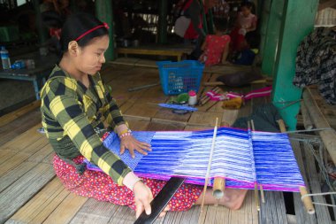 Mindat, Myanmar - 6 Aralık 2018: Ay kabilesinden kimliği belirsiz bir kadın, Mindat, Chin State, evinde geleneksel dokuma tezgahında kumaş örüyor..