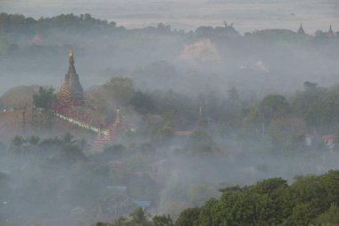 Rattanabun Chedi bakış açısında dağın tepesinden akşam manzarası ve yumuşak ışık. Vadide uzun bir sis vardı. Birçok antik pagoda görülebiliyordu. Mrauk U şehrinde. Myanmar..