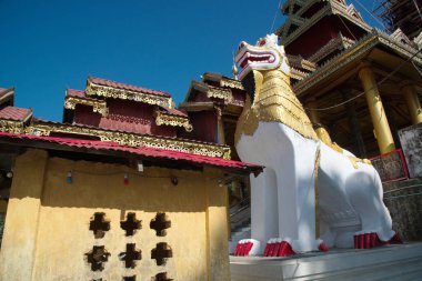 Beyaz bir aslan heykeli Wat Mahamuni Phraya tapınağındaki Budist kilisesinin önünü süslüyor. Rakhine Eyaleti, Myanmar 'da yer alır..