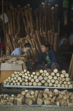 PYAY, MYANMAR - 11 Aralık 2018: Tanaka ahşabı satan tanımlanamayan bir kadın satıcı ki bu değerli bir ottur deriyi güneş ışığından korur. Derinin beslenmesine ve korunmasına yardımcı olur. 11 Aralık 2018 'de Pyay City, Myanmar' da sivilcelerin önlenmesine yardımcı olur..