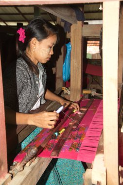 7 Aralık 2018: Geleneksel pamuk ipliklerle dokuma tezgahı üzerinde çalışan kimliği belirsiz bir kadın. Asya kültürü.