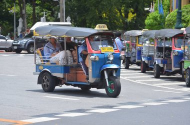 Bangkok, Tayland - 24 Ağustos 2024: Kimliği belirsiz bir adam 3 tekerlekli bir otomobil (tuk tuk) kullanıyor. Yolcuları Wat Pho 'ya bırak. 24 Ağustos 2024 'te önemli bir yer. Bu tür bir araç burada yaygın bir ulaşım biçimidir..