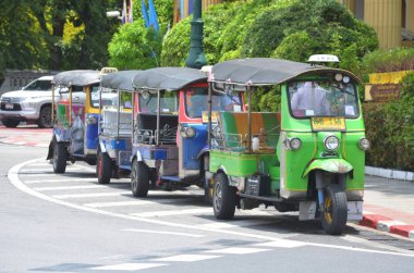 BANGKOK, THAILAND - 24 AĞUSTOS 2024: 3 tekerlekli otomobil veya Tayland sembollü Tuk-tuk Wat Pho 'da yolcuları bekliyor. Bu tür araçlar burada popüler bir ulaşım şeklidir..