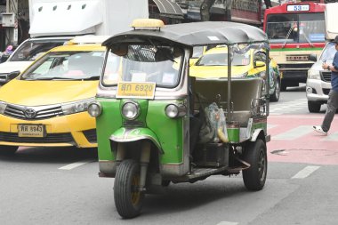 Bangkok, Tayland - 28 Ağustos 2024: Üç tekerli otomobil (tuk-tuk) ile tanımlanamayan sürücü ve turistler 28 Ağustos 2024 tarihinde Bangkok 'un başkentinde Yaowarat yolunda yolcuları alıp bırakıyorlar..