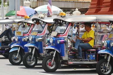 Bangkok, Tayland - 28 Ağustos 2024: 3 tekerlekli otomobil (tuk tuk tuk). 28 Ağustos 2024 'te Wat Mahathat Yuwarajarangsarit Rajaworamahavihara' da durup yolcuları beklemektedir. Bu tür bir araç burada yaygın bir ulaşım biçimidir..