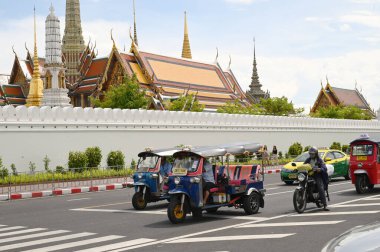 BANGKOK, THAILAND - 28 Ağustos 2024: kimliği belirsiz bir adam tuk tuk kullanıyor. Wat Phra Kaew civarına yolcu bırakın. Burası önemli bir yer. Bu tür bir araç popüler bir ulaşım şeklidir..