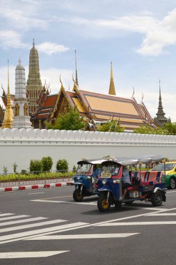BANGKOK, THAILAND - 28 Ağustos 2024: kimliği belirsiz bir adam tuk tuk kullanıyor. Wat Phra Kaew civarına yolcu bırakın. Burası önemli bir yer. Bu tür bir araç popüler bir ulaşım şeklidir..