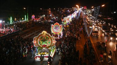 SAKON NAKHON, THAILAND - 23 ARALIK 2022: 200 'den fazla arabayla göz kamaştırıcı bir yıldızla Noel' i Noel Baba ve melekler geçit töreninde kutlamak.