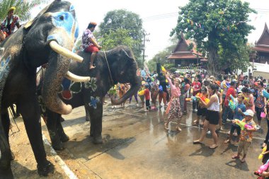 AYUTTHAYA, THAILAND -13 Nisan 2024: Tanımlanamayan turistler ve Taylandlılar plastik tabanca veya kase kullanarak fillere su sıçratmada birleşiyorlar. Tayland 'daki Ayutthaya Tarih Parkındaki Songkran Festivali' nde iyi eğlenceler..