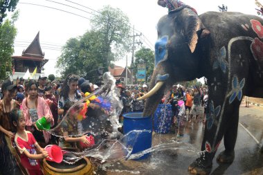 AYUTTHAYA, THAILAND -13 Nisan 2024: Tanımlanamayan turistler ve Taylandlılar plastik tabanca veya kase kullanarak fillere su sıçratmada birleşiyorlar. Tayland 'daki Ayutthaya Tarih Parkındaki Songkran Festivali' nde iyi eğlenceler..