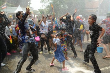AYUTTHAYA, THAILAND - 13 Nisan 2024: Kimliği belirsiz bir turist ve Tayland vatandaşları Tayland 'daki Ayutthaya Tarih Parkında düzenlenen Songkran Festivali sırasında su sıçratıp dans ediyorlar.