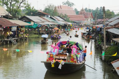 SAMUT SONGKHRAM, Tayland - 11 Aralık 2023: Amphawa Yüzen Pazar alanı ve topluluk, su yoluyla sadaka verme geleneğini yeniden canlandırdı. Bu, Amphawa Kanalı 'ndaki insanların eski bir geleneği olarak kabul edilir..
