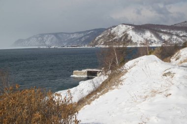 Buzsuz Angara Nehri 'nin manzarası donmuş Baykal Gölü' nden akıyor. Erimiş buz mavi suda yüzer. Rusya 'da Baykal Gölü, Listvyanka kenti.