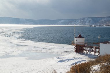 Buzsuz Angara Nehri 'nin manzarası donmuş Baykal Gölü' nden akıyor. Erimiş buz mavi suda yüzer. Rusya 'da Baykal Gölü, Listvyanka kenti.