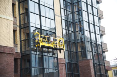 IRKUTSK, RUSSIA - 12 Mart 2020: Yüksek binadaki pencereleri temizleyen kimliği belirsiz işçiler.