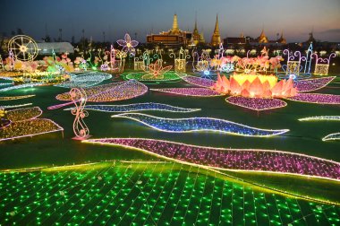 BANGKOK , THAILAND - DECEMBER 23 , 2024 : Twilight time of beautiful outdoor flower lights at Sanam Luang to worship the Buddha's tooth relic to create interest in Buddhism. clipart