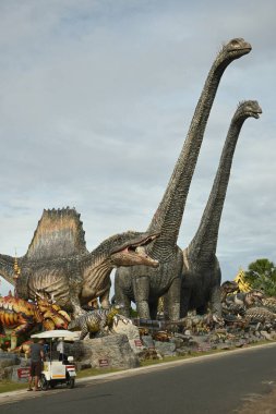 CHON BURI, THAILAND - 24 Eylül 2023: Sauroposeidon dinozor heykelleri ve Nong Nooch Tropikal Bahçesi 'ndeki Dinozor Vadisi' ndeki çeşitli boyutlar.