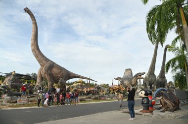 CHON BURI, THAILAND - 24 Eylül 2023: Sauroposeidon dinozor heykelleri ve Nong Nooch Tropikal Bahçesi 'ndeki Dinozor Vadisi' ndeki çeşitli boyutlar.