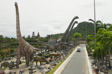 CHON BURI, THAILAND - 24 Eylül 2023: Sauroposeidon dinozor heykelleri ve Nong Nooch Tropikal Bahçesi 'ndeki Dinozor Vadisi' ndeki çeşitli boyutlar.