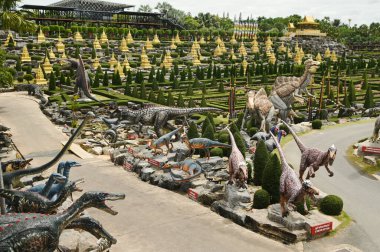 CHON BURI, THAILAND - 6 Eylül 2023 Nong Nooch Tropikal Bahçesi 'ndeki Dinozor Vadisi' nde güzel bir dinozor heykeli ve çeşitli boyutlarda başka bir turistik alan.