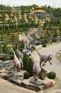 CHON BURI, THAILAND - 6 Eylül 2023 Nong Nooch Tropikal Bahçesi 'ndeki Dinozor Vadisi' nde güzel bir dinozor heykeli ve çeşitli boyutlarda başka bir turistik alan.