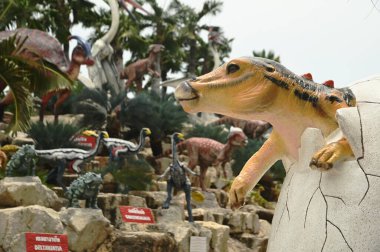 CHON BURI, THAILAND - 6 Eylül 2023: Nong Nooch Tropikal Bahçesi 'ndeki Dinozor Vadisi' nde çeşitli boyutlarda güzel dinozor heykelleri, bir başka büyük turistik ilgi alanı.