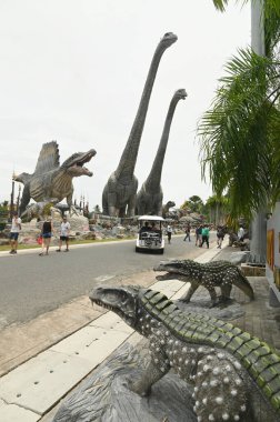 CHON BURI, THAILAND - 24 Eylül 2023: Sauroposeidon dinozor heykelleri ve Nong Nooch Tropikal Bahçesi 'ndeki Dinozor Vadisi' ndeki çeşitli boyutlar.