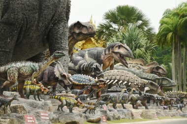 CHON BURI, THAILAND - 6 Eylül 2023: Nong Nooch Tropikal Bahçesi 'ndeki Dinozor Vadisi' nde çeşitli boyutlarda güzel dinozor heykelleri, bir başka büyük turistik ilgi alanı.