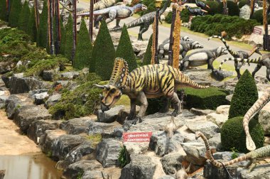 CHON BURI, THAILAND - 6 Eylül 2023: Nong Nooch Tropikal Bahçesi 'ndeki Dinozor Vadisi' nde çeşitli boyutlarda güzel dinozor heykelleri, bir başka büyük turistik ilgi alanı.