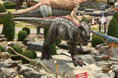 CHON BURI, THAILAND - 6 Eylül 2023: Nong Nooch Tropikal Bahçesi 'ndeki Dinozor Vadisi' nde çeşitli boyutlarda güzel dinozor heykelleri, bir başka büyük turistik ilgi alanı.