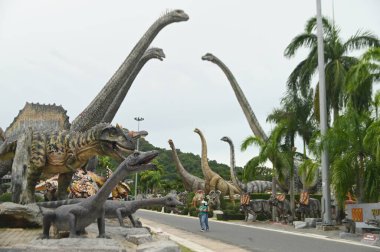 CHON BURI, THAILAND - 6 Eylül 2023: Nong Nooch Tropikal Bahçesi 'ndeki Dinozor Vadisi' nde çeşitli boyutlarda güzel dinozor heykelleri, başka bir büyük turistik ilgi alanı.