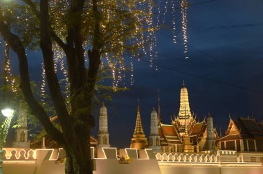 Güneşin batışındaki güzel ışıklar Wat Phra Kaew 'i süslüyor. Burası dünyanın dört bir yanındaki Budistler için saygı ve turizm yeri..