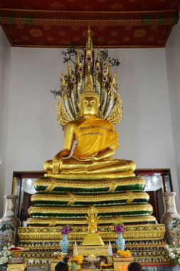 Naga Hood Buda heykeli tarafından korunan Buda heykeli Wat Phra Chetuphon Wimonmangklaram veya Wat Pho 'daki batı tapınağında her iki turist arasında popülerdir..