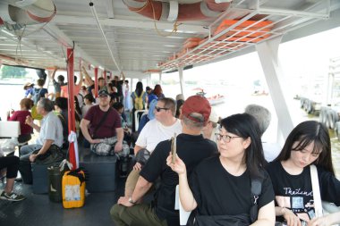 BANGKOK, THAILAND - 23 Şubat 2025: Feribotlardaki çeşitli yolcuların tanımlanamaması Chao Phraya Nehri 'nde seyahat etmek için kullanılan geleneksel ahşap teknelerdir. Bangkok su turizmini destekliyor ve çok popüler..