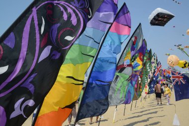 CHON BURI, THAILAND - 2 Mart 2025: 2025 Pattaya sahilindeki Pattaya Uluslararası Uçurtması 'nda renkli bayraklar sırası. Bu etkinlik turizmi tanıtmak için düzenlenmiştir..