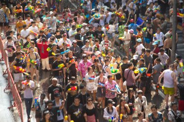 BANGKOK, THAILAND - 14 Nisan 2024: Tayland ve yabancı turistler Songkran Günü 'nde (Tayland Yeni Yıl / Su Festivali) sokaklara dans ederek, ateş ederek ve Silom yoluna su dökerek su sıçratıyorlar.