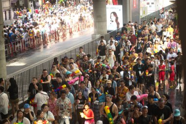 BANGKOK, THAILAND - 14 Nisan 2024: Tayland ve yabancı turistler Songkran Günü 'nde (Tayland Yeni Yıl / Su Festivali) sokaklara dans ederek, ateş ederek ve Silom yoluna su dökerek su sıçratıyorlar.