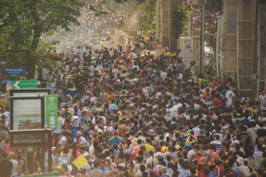 BANGKOK, THAILAND - 14 Nisan 2024: Tayland ve yabancı turistler Songkran Günü 'nde (Tayland Yeni Yıl / Su Festivali) sokaklara dans ederek, ateş ederek ve Silom yoluna su dökerek su sıçratıyorlar.