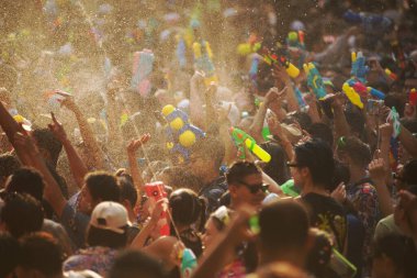BANGKOK, THAILAND - 14 Nisan 2024: Songkran Günü (Tayland Yeni Yıl / Su Festivali) sokaklara su sıçratan turistler dans ederek, ateş ederek ve Silom yoluna su dökerek.