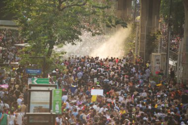 BANGKOK, THAILAND - 14 Nisan 2024: Songkran Günü (Tayland Yeni Yıl / Su Festivali) sokaklara su sıçratan turistler dans ederek, ateş ederek ve Silom yoluna su dökerek.