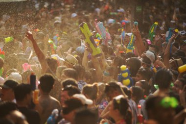 BANGKOK, THAILAND - 14 Nisan 2024: Songkran Günü (Tayland Yeni Yıl / Su Festivali) sokaklara su sıçratan turistler dans ederek, ateş ederek ve Silom yoluna su dökerek.