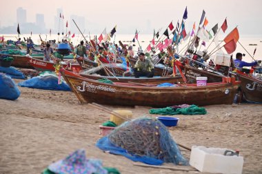 CHON BURI, THAILAND -HAZİRAN 18, 2025 Tayland yerel balıkçıları Na Jomtien Sahili, Pattaya 'da balık ve balık ağları topluyor. Taylandlı balıkçılar, geleneksel ahşap teknelerde ağlarla ya da tuzaklarla balık yakalıyorlar..