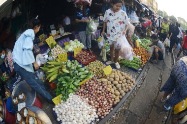 SAMUT SAKHON, THAILAND - 29 Eylül 2024: Kimliği belirsiz bir satıcı Mahachai İstasyonu 'nda sebze, meyve satıyor. Tren geldiğinde, rafları yerinde bırakıyor çünkü daha aşağıda....