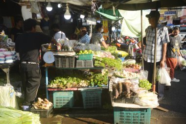 SAMUT SAKHON, THAILAND - 9 Eylül 2024: Kimliği belirsiz bir satıcı Mahachai İstasyonu 'nda sebze, meyve satıyor. Tren geldiğinde, rafları yerinde bırakıyor çünkü daha aşağıda....