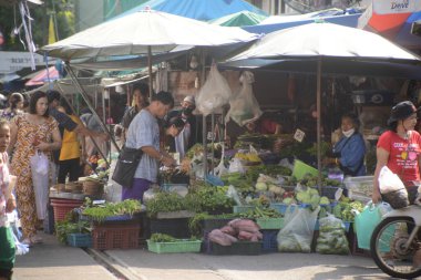 SAMUT SAKHON, THAILAND - 9 Eylül 2024: Kimliği belirsiz bir satıcı Mahachai İstasyonu 'nda sebze, meyve satıyor. Tren geldiğinde, rafları yerinde bırakıyor çünkü daha aşağıda....